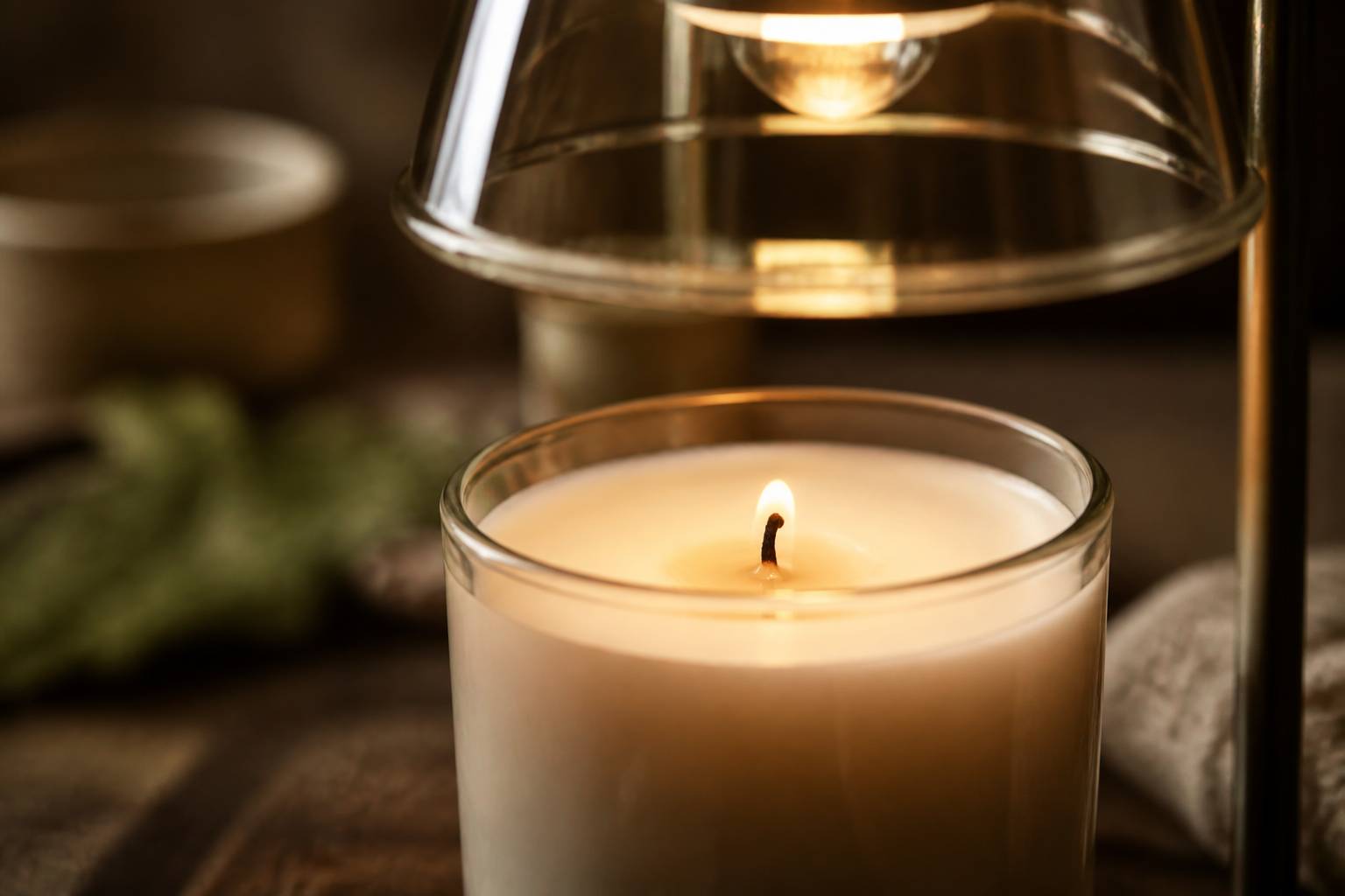 Gros plan sur la cire d'une bougie fondant sous une lampe chauffe-bougie
